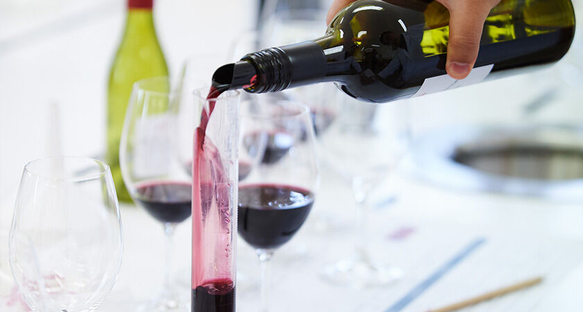 Red wine being poured into test tube